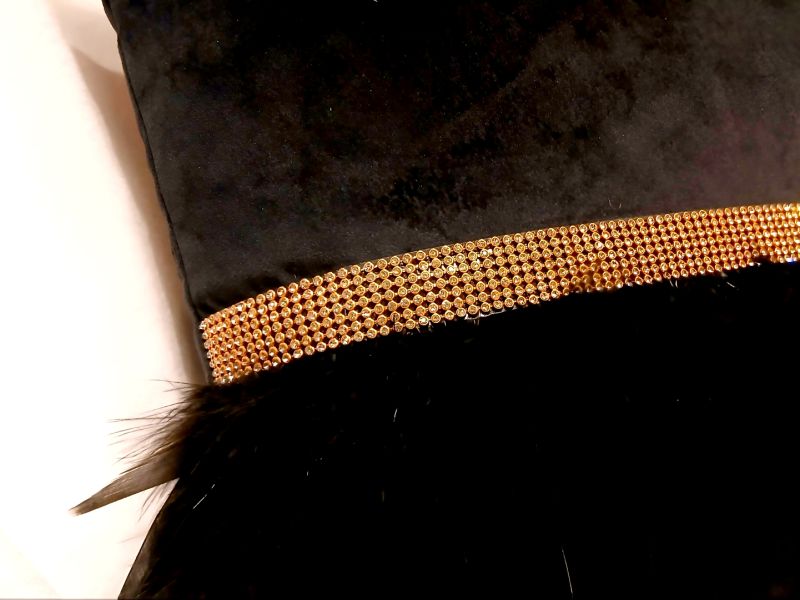 Cojín negro con flecos de plumas y pedrería