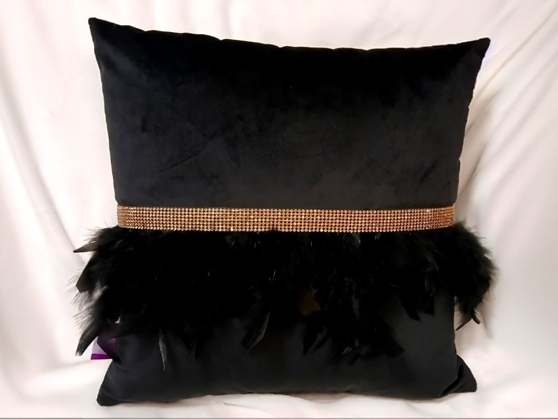 Cojín negro con flecos de plumas y pedrería