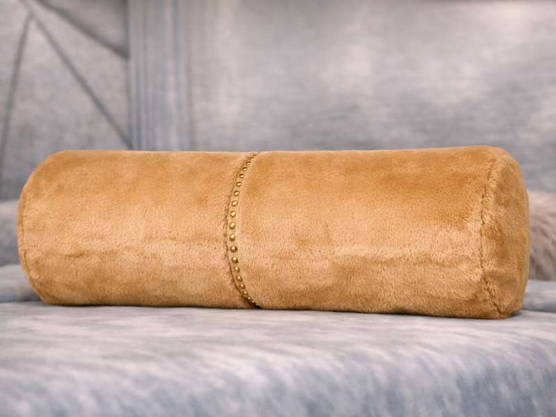 Cojín cilíndrico con tachuelas decorativas